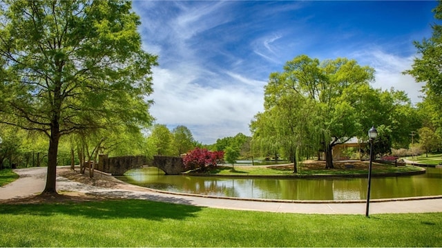 view of community with a water view and a lawn