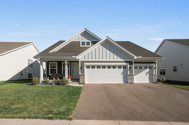 craftsman-style home featuring covered porch, a garage, and a front lawn