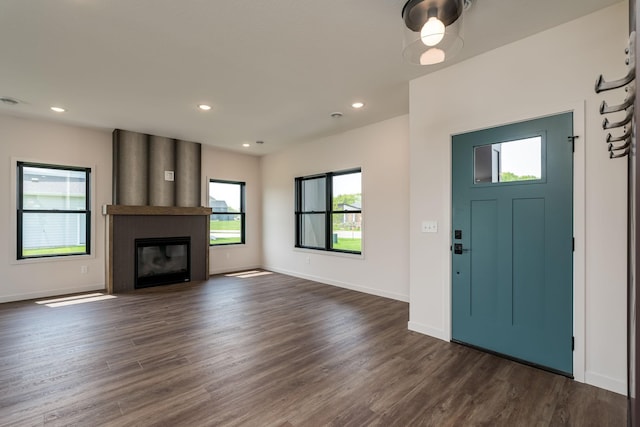 entrance foyer with dark hardwood / wood-style flooring and a fireplace