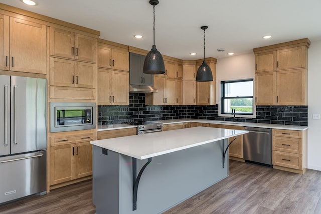 kitchen with pendant lighting, a center island, stainless steel appliances, and sink