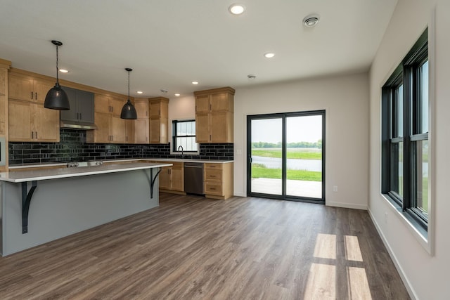 kitchen with appliances with stainless steel finishes, a kitchen island, hanging light fixtures, and a breakfast bar area