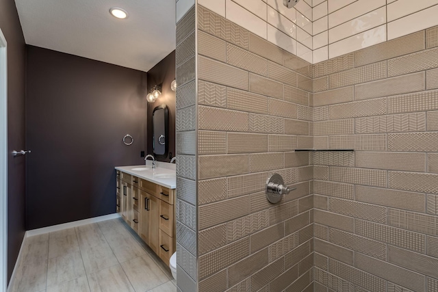 bathroom with vanity and a tile shower