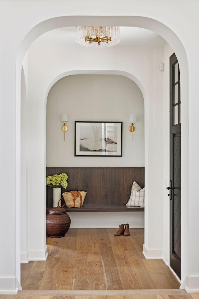 corridor featuring hardwood / wood-style floors and a chandelier