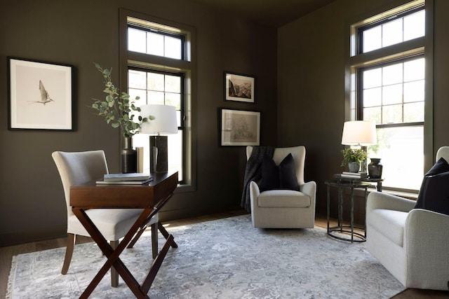 living area with a wealth of natural light and hardwood / wood-style flooring