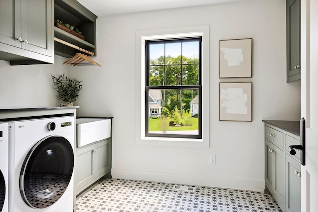 washroom with washer and dryer and cabinets