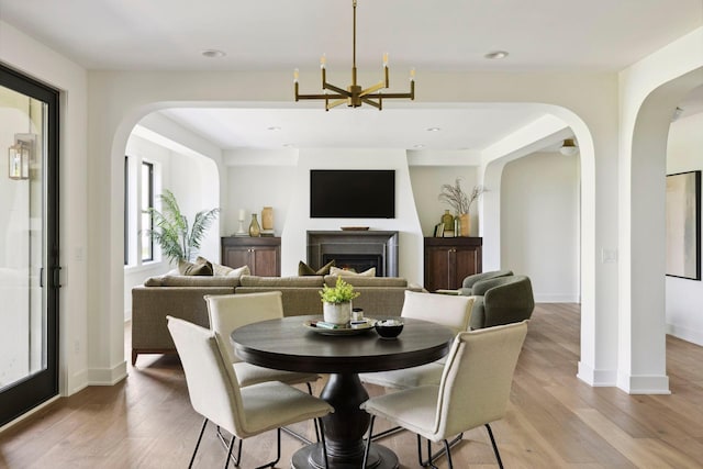 dining area with an inviting chandelier and light hardwood / wood-style flooring