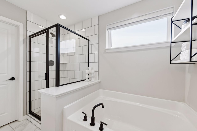 bathroom featuring shower with separate bathtub