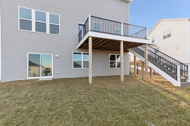 rear view of property featuring a lawn and a wooden deck