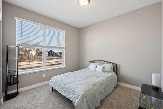 bedroom featuring light carpet and baseboards