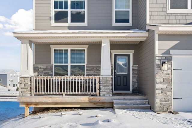 snow covered property entrance with a porch