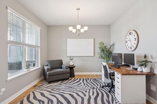 office space featuring baseboards, light wood finished floors, and a notable chandelier