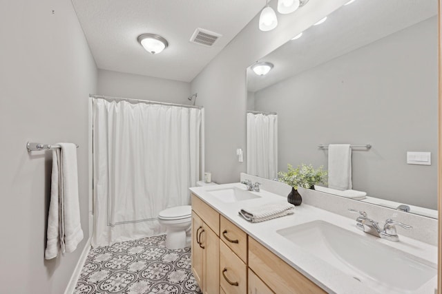 bathroom with double vanity, visible vents, a sink, and tile patterned floors