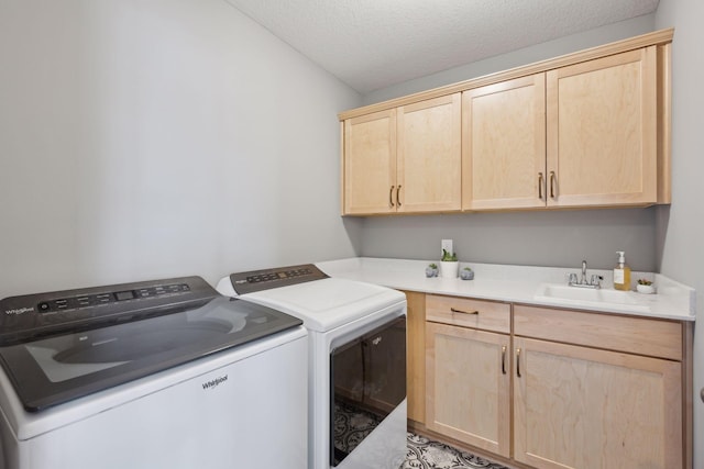 clothes washing area featuring washer and dryer, cabinet space, a sink, and a textured ceiling