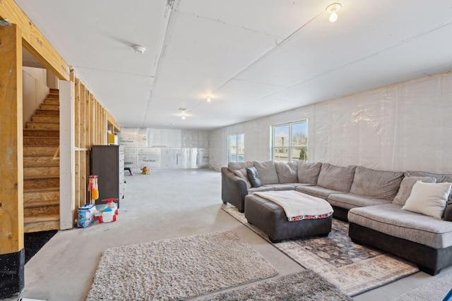 living room featuring concrete floors and stairway