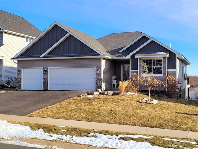 craftsman-style home with a garage and a yard