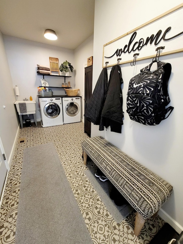 clothes washing area with sink and washing machine and clothes dryer