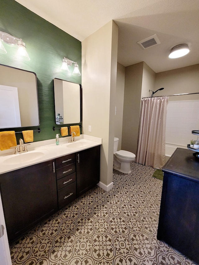 bathroom with toilet, a shower with shower curtain, vanity, and tile patterned floors