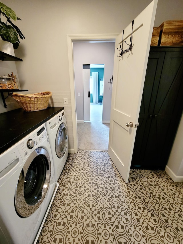 clothes washing area featuring washer and clothes dryer and light tile patterned floors