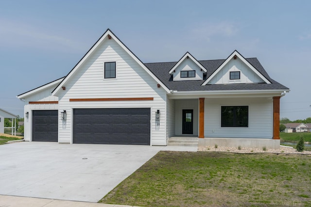 view of front of home with a porch, a front yard, and a garage