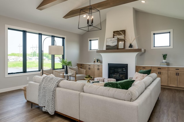 living room featuring a fireplace, vaulted ceiling with beams, dark wood-type flooring, and a notable chandelier