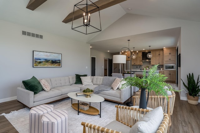 living room featuring dark hardwood / wood-style flooring, high vaulted ceiling, a chandelier, and sink