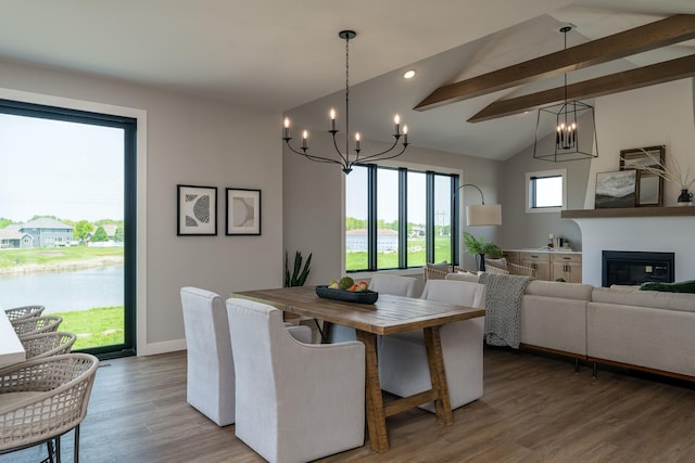 dining area featuring vaulted ceiling with beams, a water view, wood-type flooring, and a notable chandelier