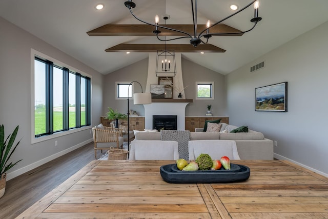 living room featuring a notable chandelier, vaulted ceiling with beams, and light wood-type flooring