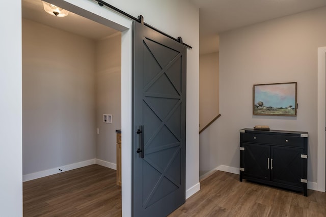 entryway with a barn door and wood-type flooring