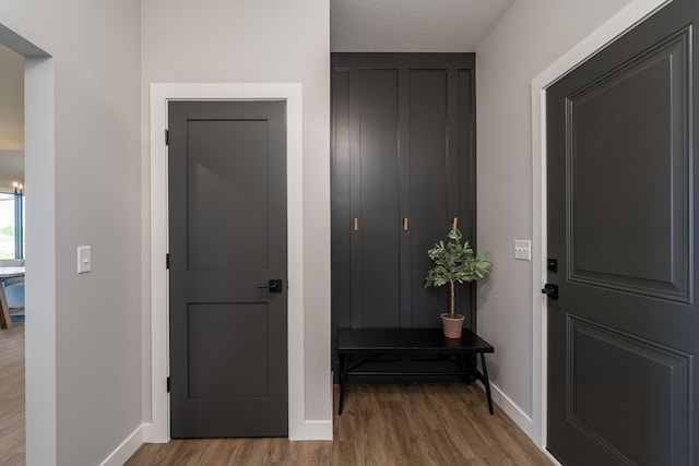 corridor featuring light hardwood / wood-style floors and a textured ceiling