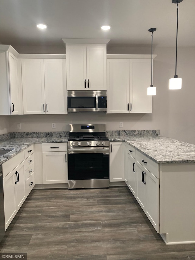 kitchen featuring dark hardwood / wood-style floors, white cabinetry, stainless steel appliances, and decorative light fixtures