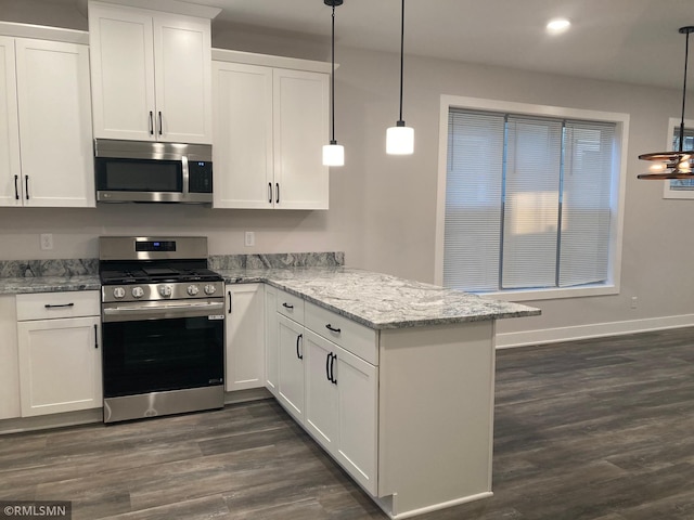 kitchen featuring white cabinets, decorative light fixtures, dark hardwood / wood-style flooring, kitchen peninsula, and stainless steel appliances