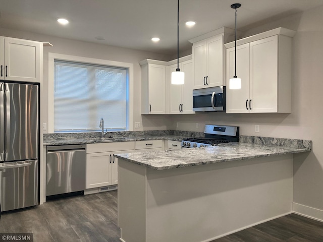 kitchen with white cabinets, decorative light fixtures, stainless steel appliances, and sink