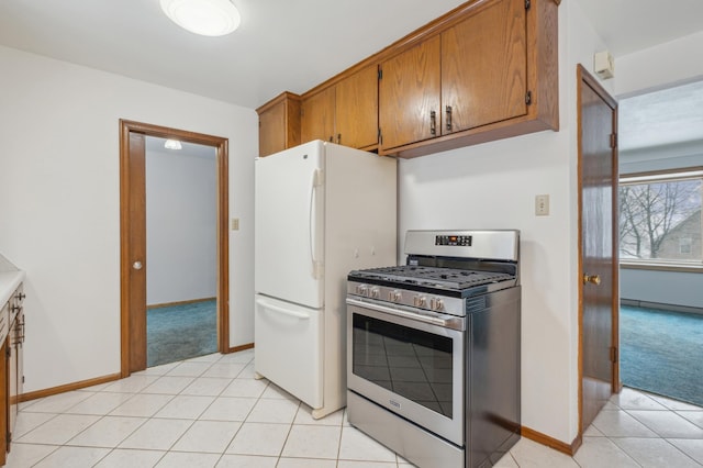 kitchen featuring gas range, white fridge, and light tile patterned floors