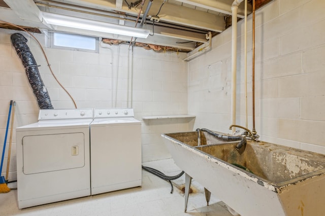 clothes washing area with washer and clothes dryer and sink