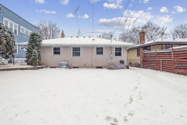 view of snow covered back of property