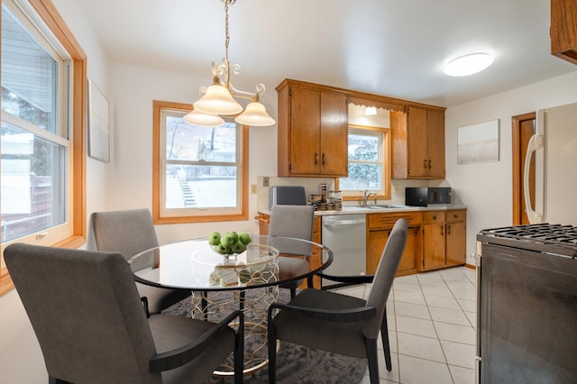 kitchen with dishwasher, refrigerator, light tile patterned floors, decorative light fixtures, and range