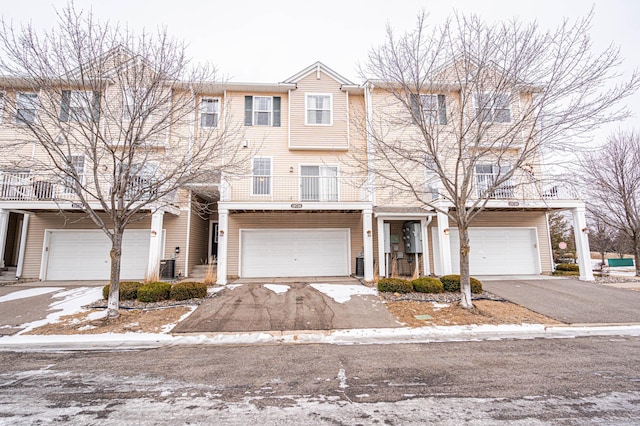 view of property with a garage and central air condition unit