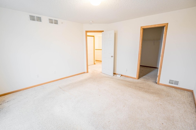 carpeted spare room with a textured ceiling