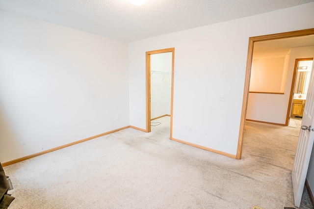 carpeted empty room featuring a textured ceiling