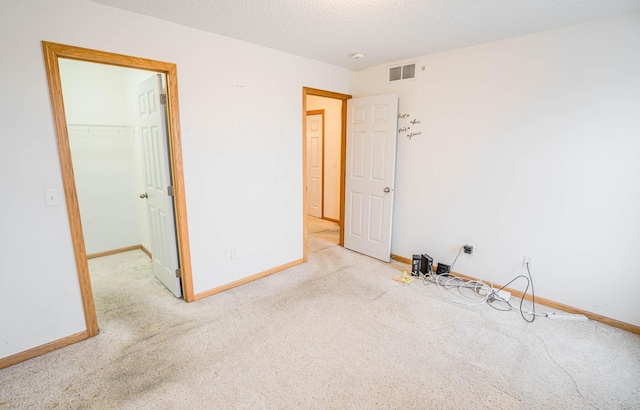 carpeted empty room featuring a textured ceiling