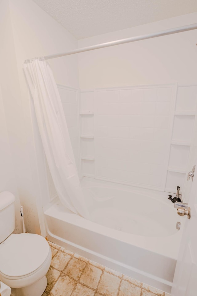 bathroom with shower / bath combination with curtain, toilet, and a textured ceiling