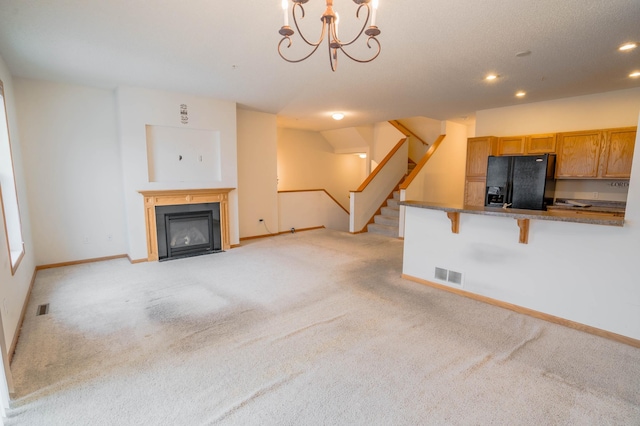 unfurnished living room featuring light carpet and a notable chandelier