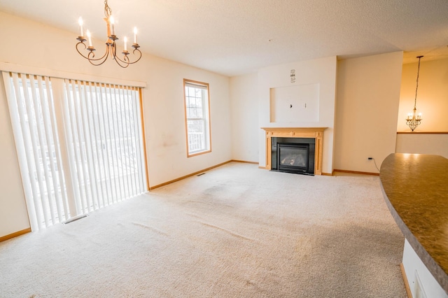 unfurnished living room with a chandelier and carpet