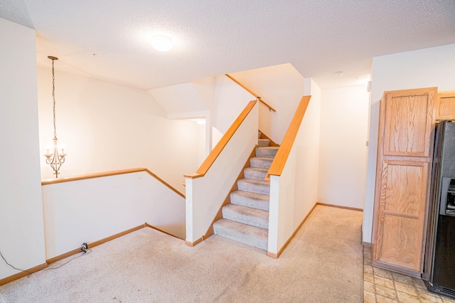 stairway with vaulted ceiling, carpet flooring, a notable chandelier, and a textured ceiling