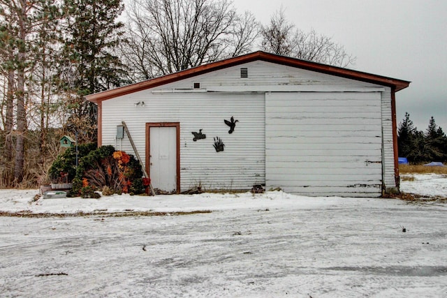 snow covered structure featuring a garage