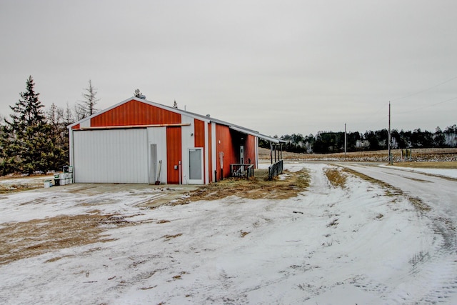 snow covered structure featuring a garage