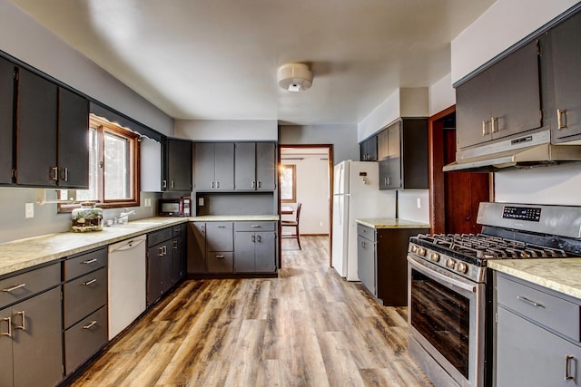 kitchen featuring sink, white appliances, and light hardwood / wood-style flooring