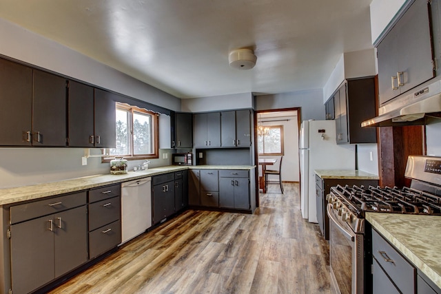 kitchen with white appliances, a healthy amount of sunlight, light wood-type flooring, and sink