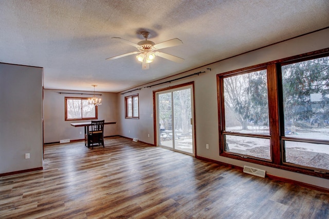 spare room featuring ceiling fan with notable chandelier, a textured ceiling, hardwood / wood-style floors, and crown molding