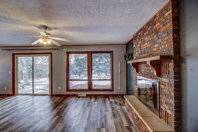 unfurnished living room featuring a fireplace, a textured ceiling, ceiling fan, and wood-type flooring